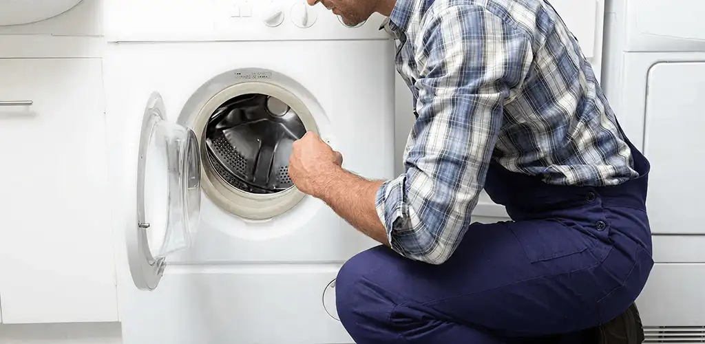 Handyman inspecting a dryer drum and internal parts for repair in Richmond, VA