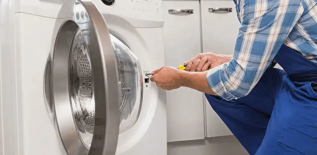 Handyman repairing a clothes dryer and checking electrical connections in Richmond, VA