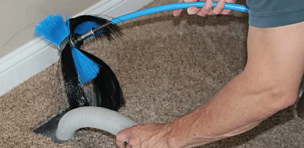 Dryer vent cleaning technician brushing lint from a vent line in Richmond, VA