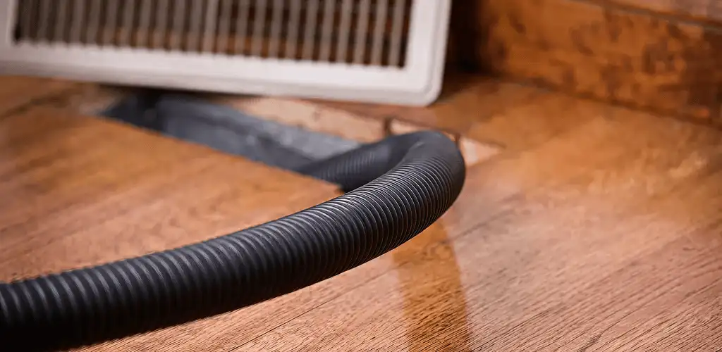 Air duct cleaning hose inserted into a floor vent for ductwork cleaning in Richmond, VA