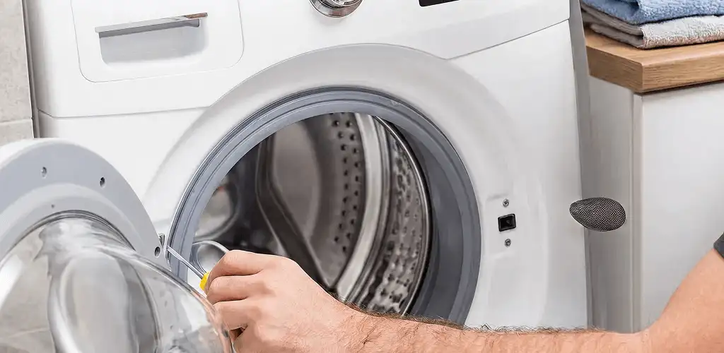 Handyman repairing a front-load washing machine and inspecting the drum in Richmond, VA