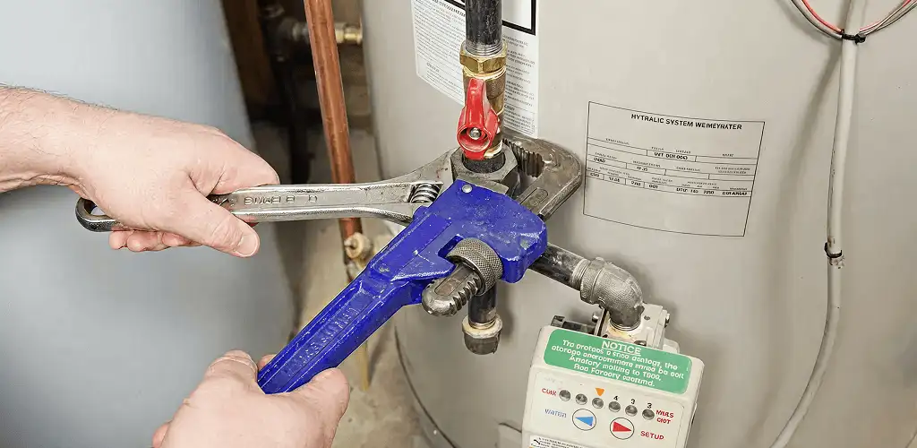 Water heater repair technician tightening the shutoff valve and supply line in Richmond, VA